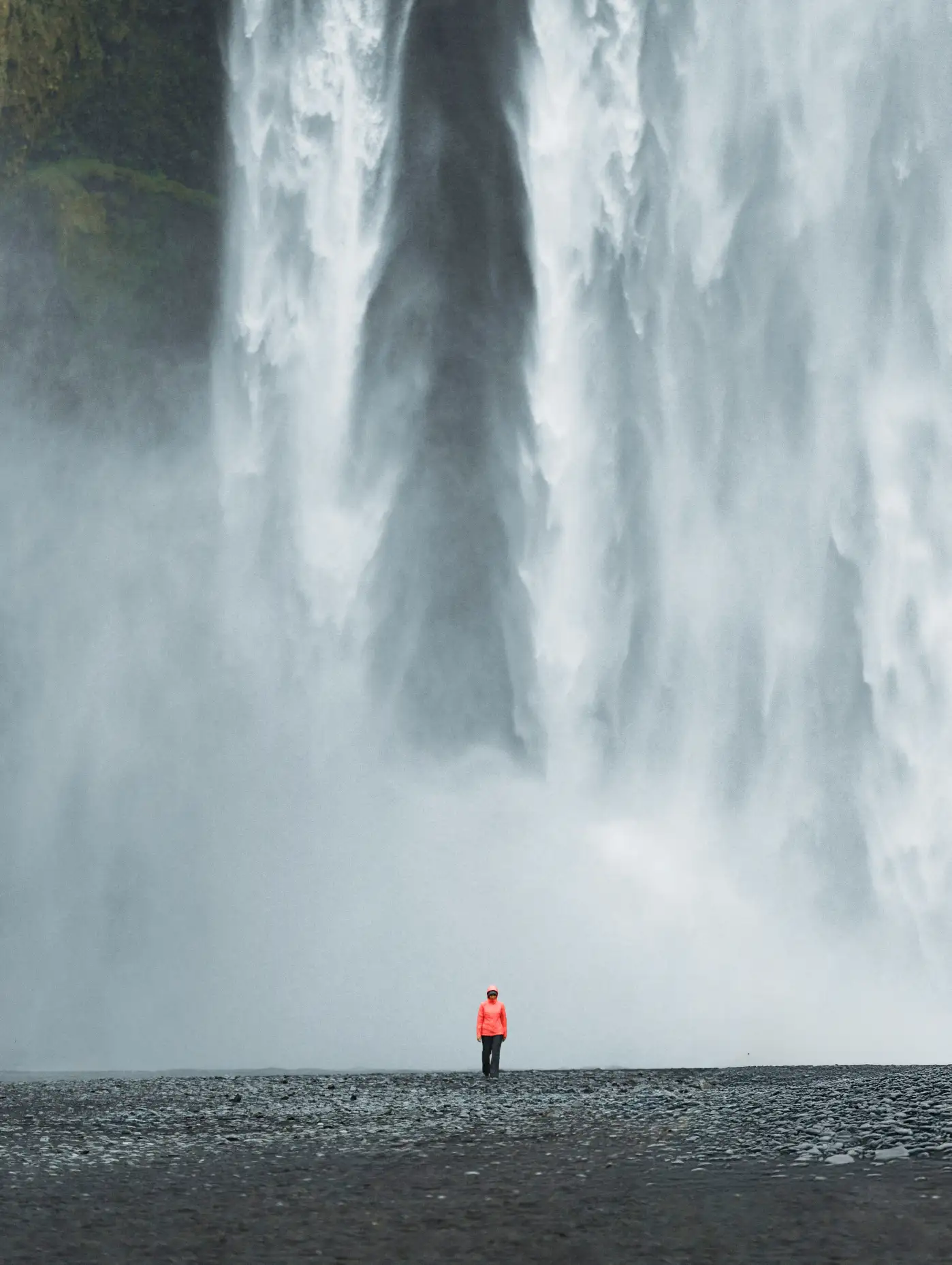 human in front of waterfall